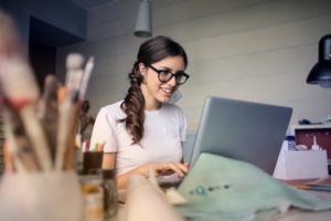 young woman in glasses using a laptop